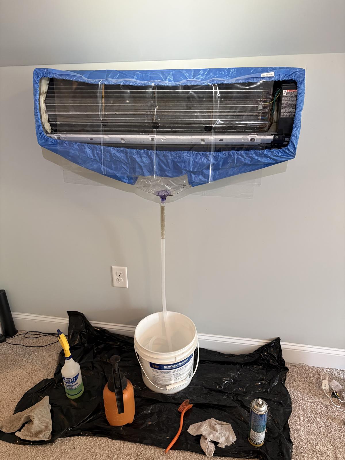 Sid's Heating & Air technician cleaning a ductless mini-split head