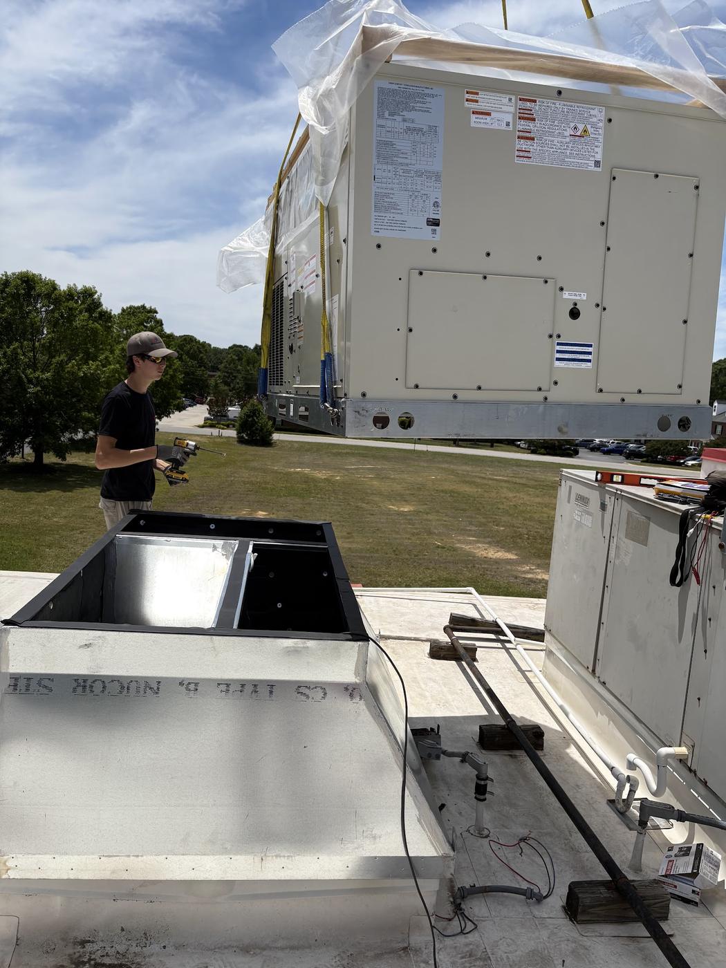 New rooftop HVAC unit staged for installation on a commercial roof
