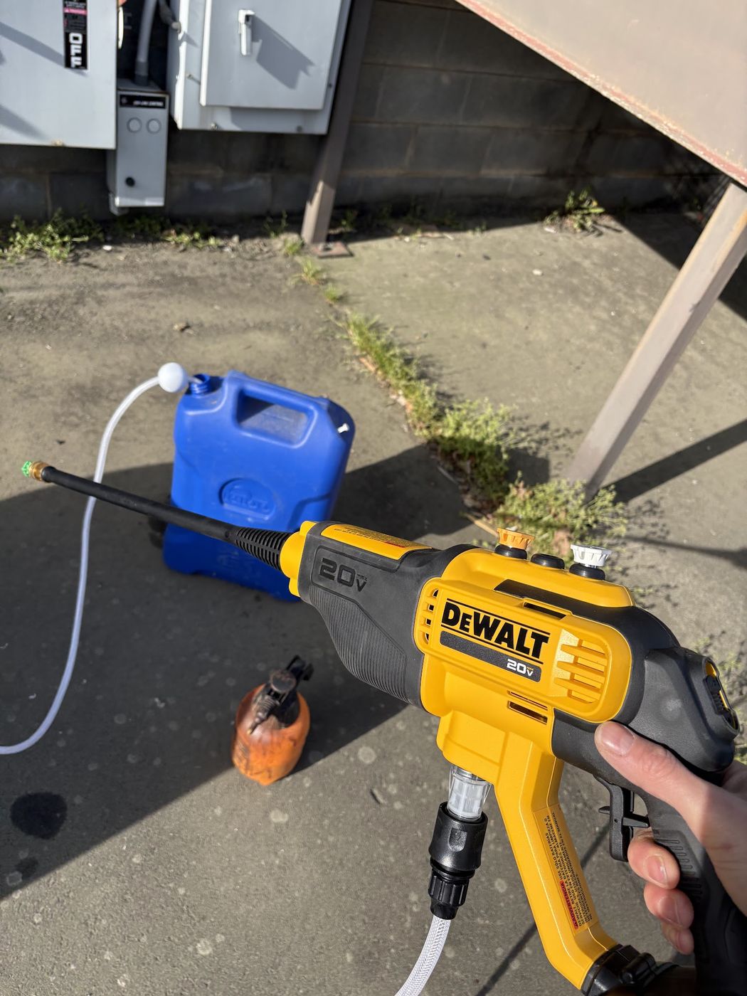 Condenser coil being cleaned with a powered sprayer