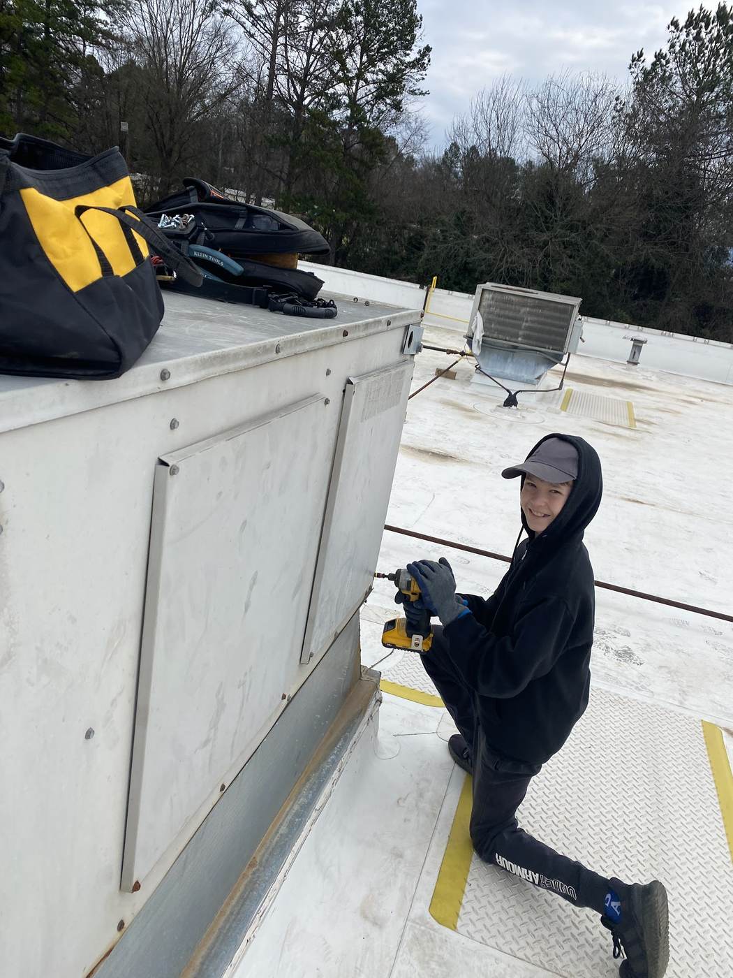 Sid's Heating and Air technician working on a flat commercial roof