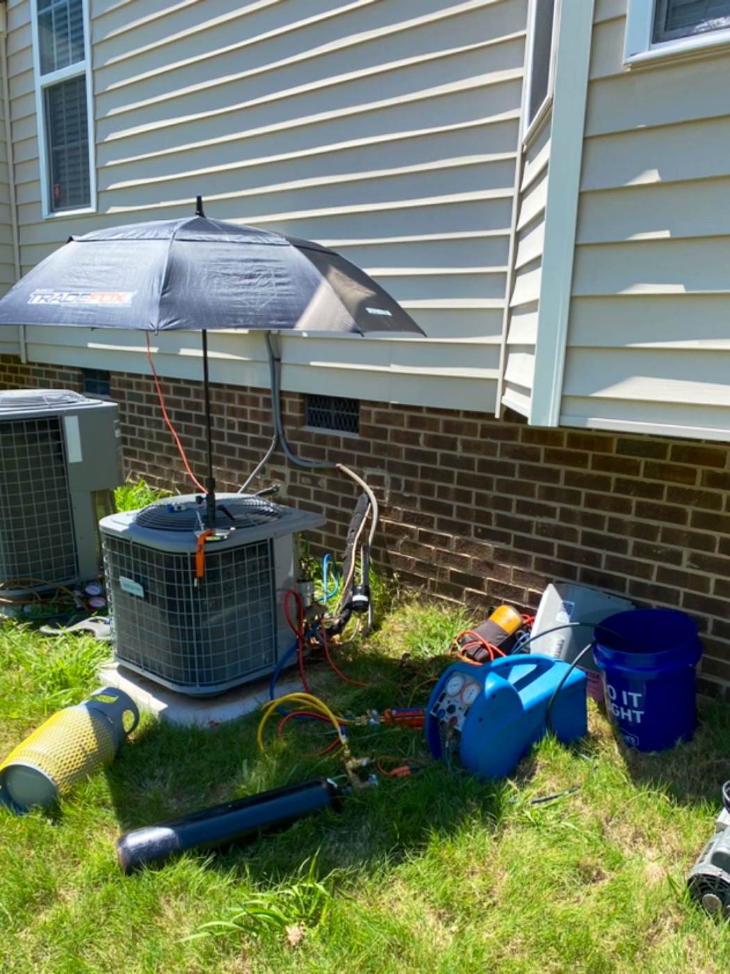 AC condenser mid-service with tools and gauges on site