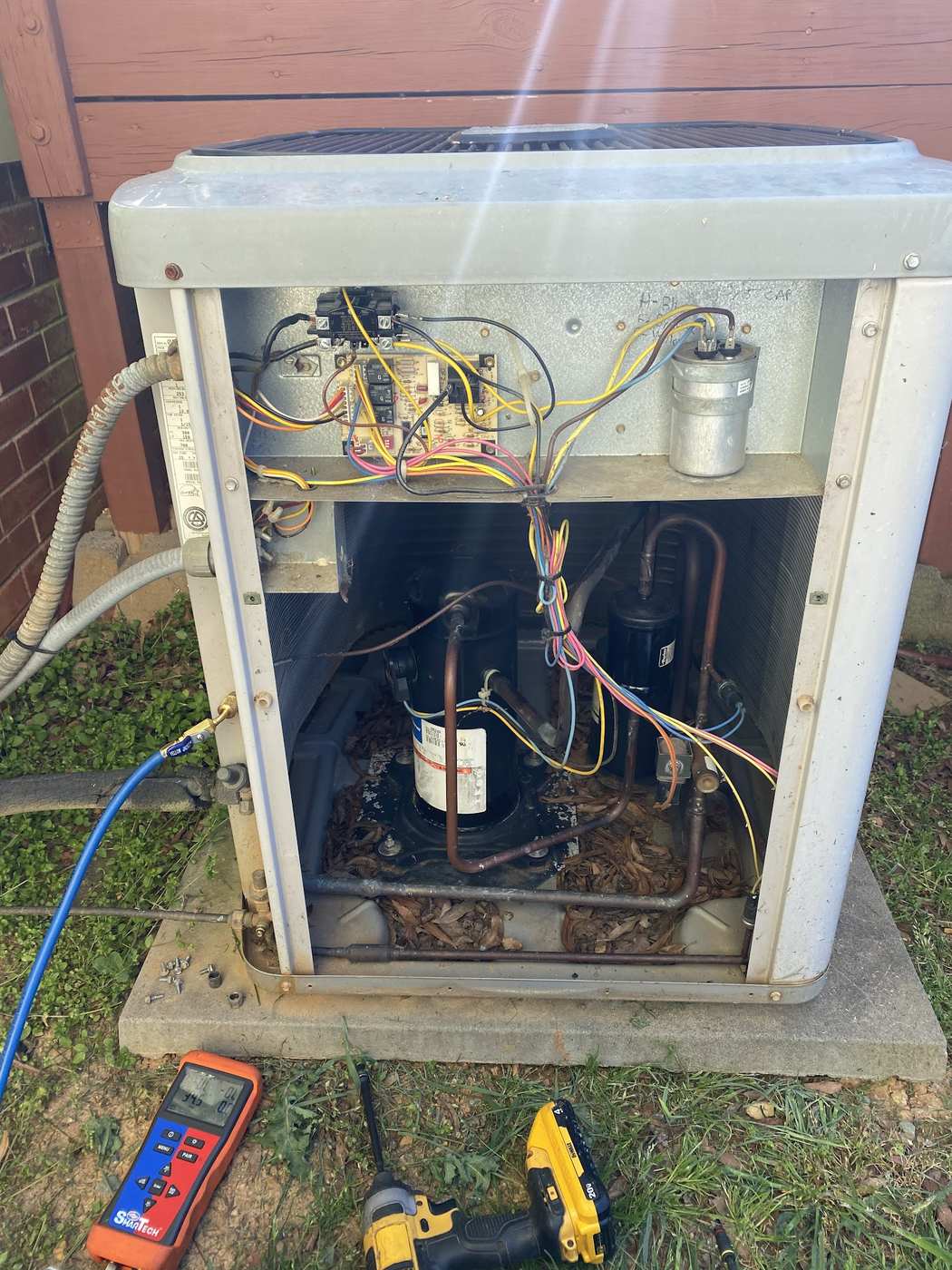 Condenser electrical compartment being tested with a meter