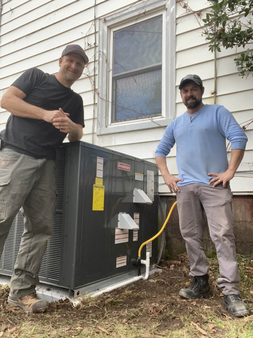 Two Sid's Heating and Air technicians on an outdoor unit changeout