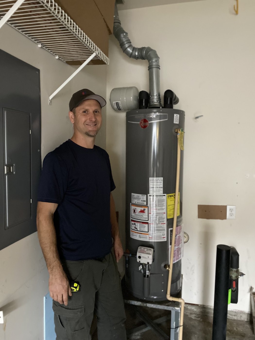 Technician beside a residential water heater