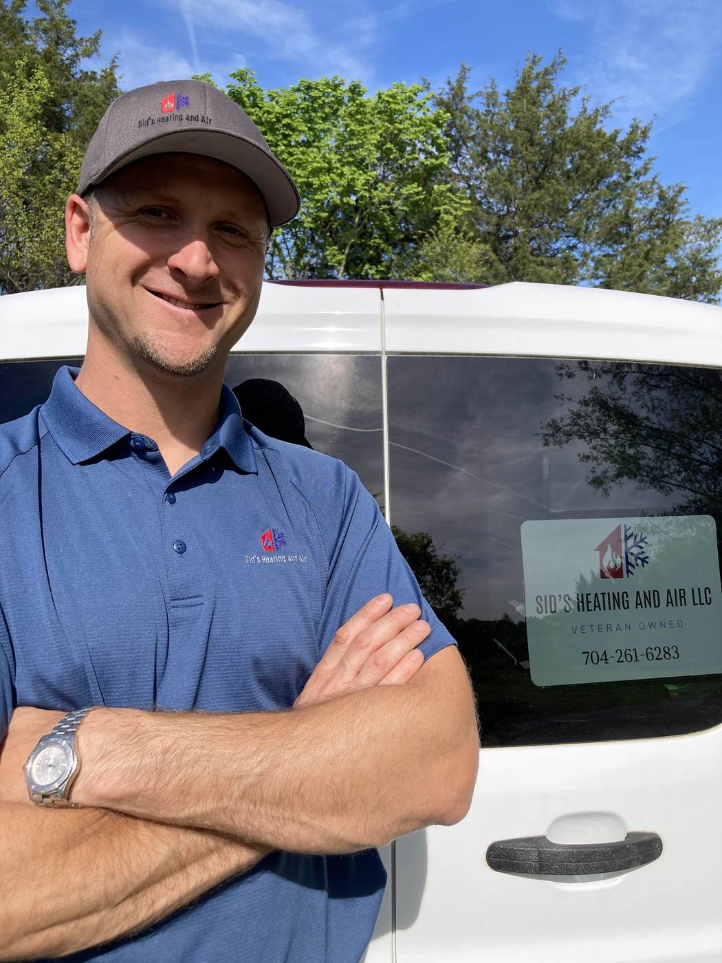 Sid's Heating and Air technician beside the service van